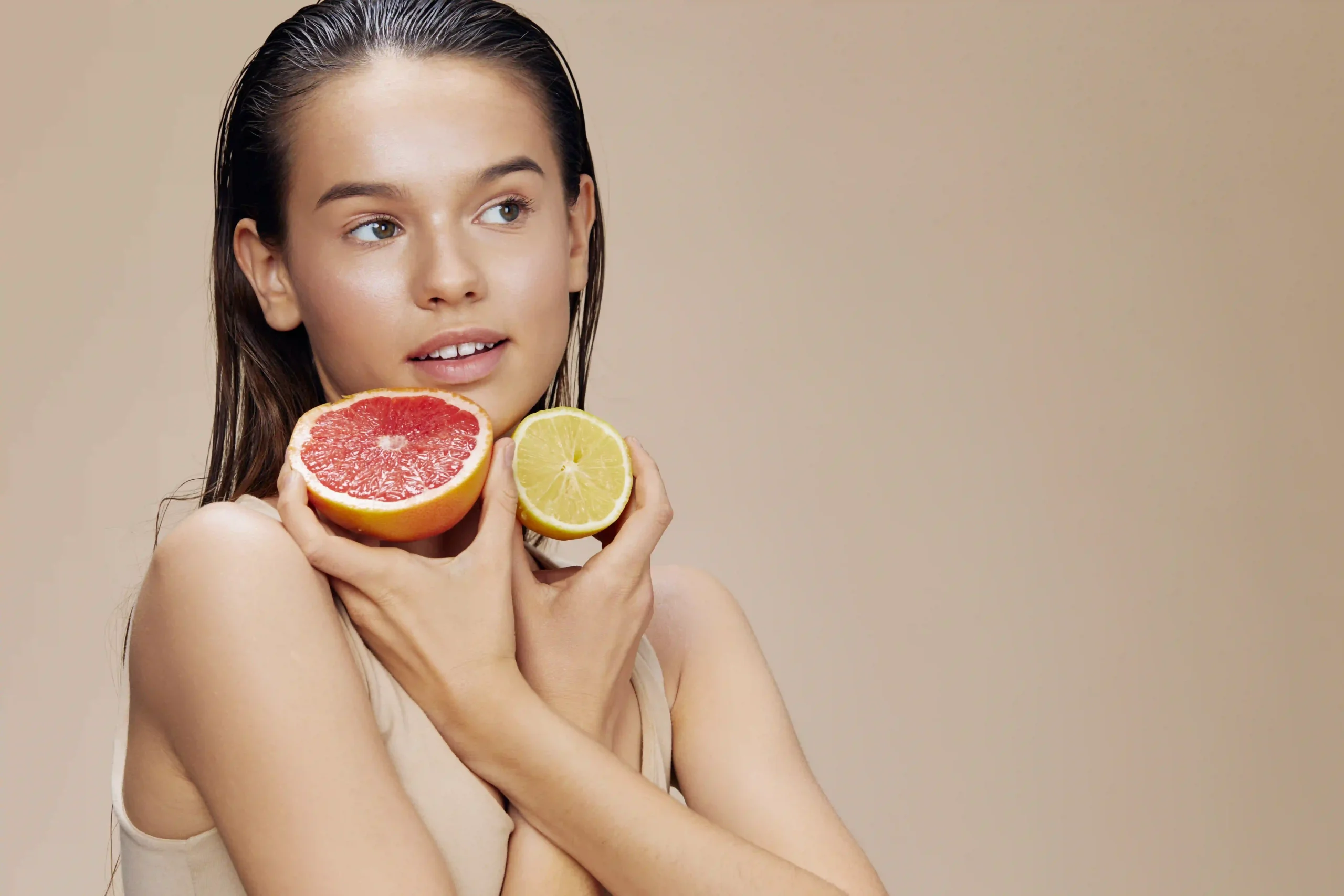 Woman holding grapefruit and lemon slices.